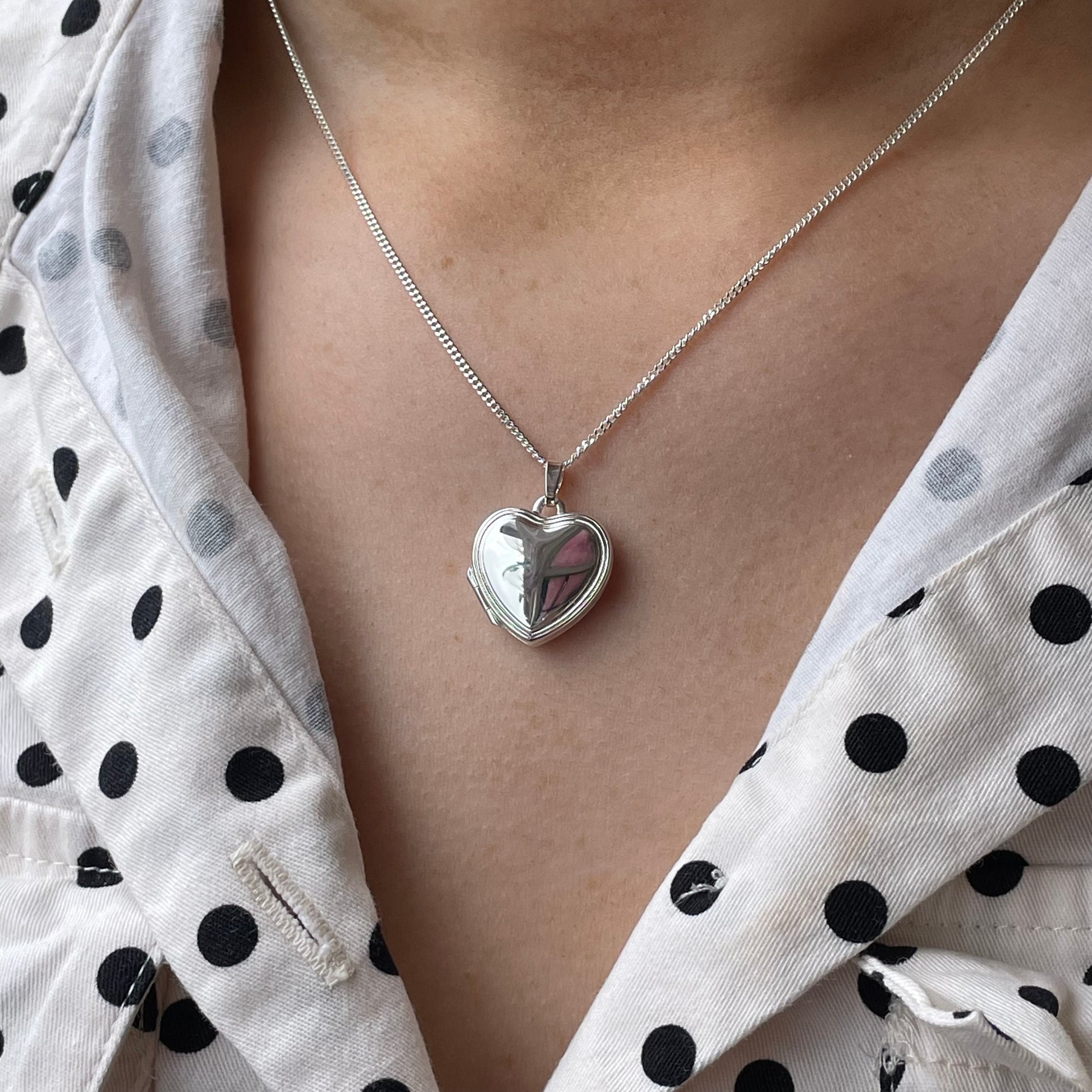 Silver stepped border heart locket necklace by Clandela, featuring a detailed heart-shaped pendant with elegant stepped border design.
