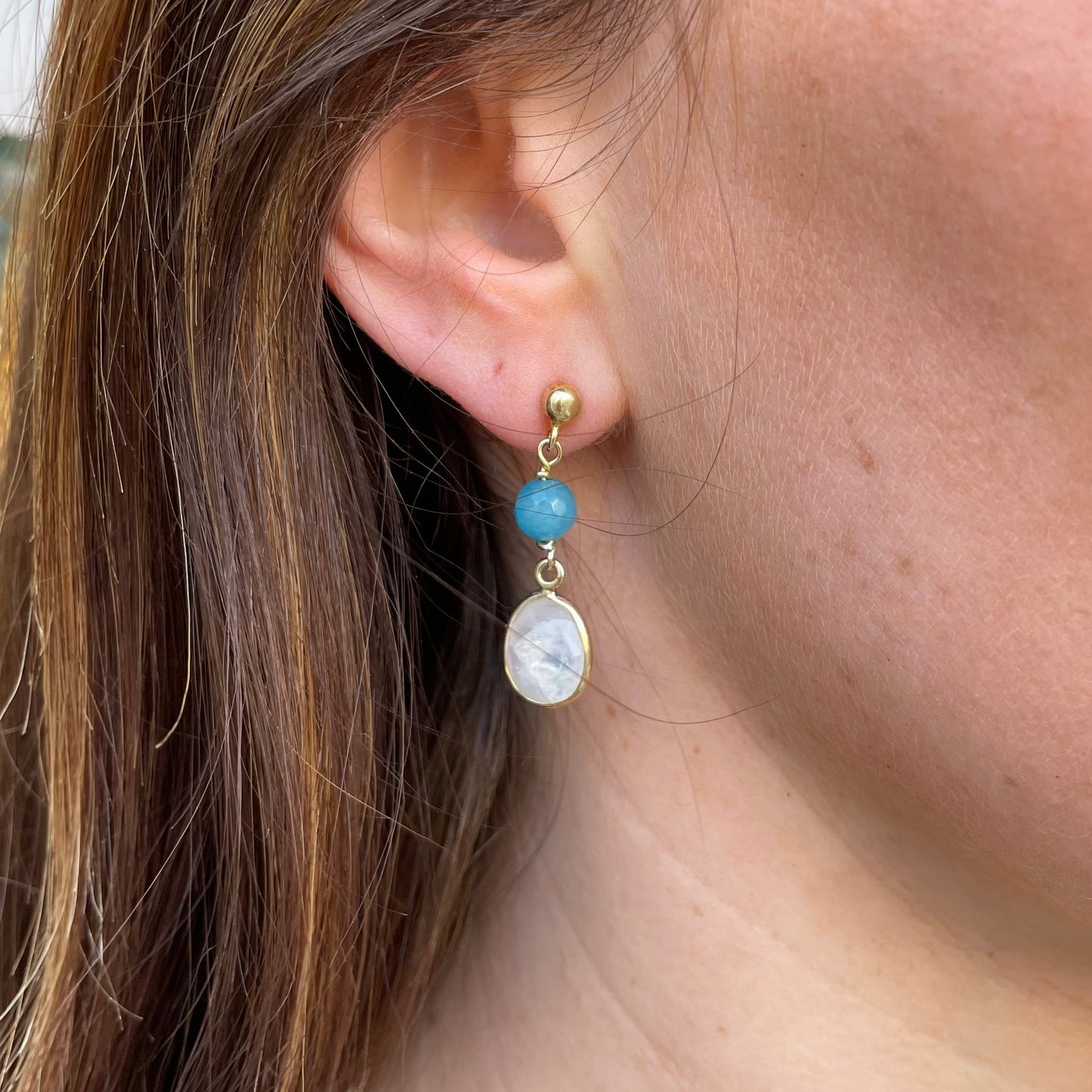 Bruno blue agate and opal drop earrings with teardrop-shaped stones hanging from silver hooks.