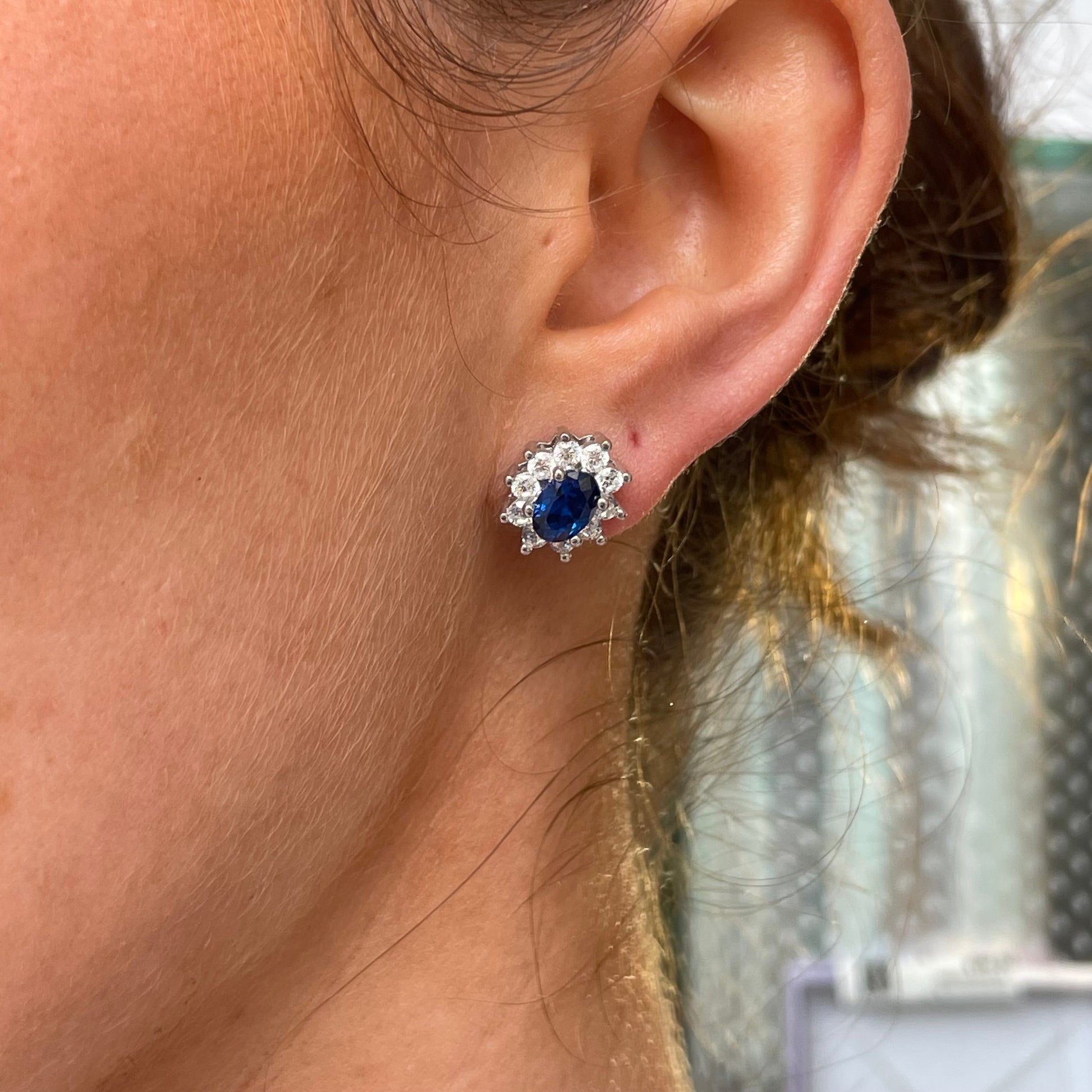 Silver oval CZ Diana stud earrings with sapphire blue accents from Comero, featuring a sleek and elegant jewelry design.