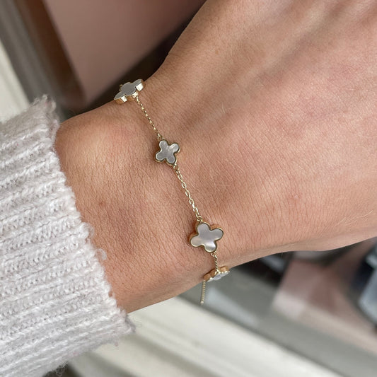 9ct gold mother of pearl graduated quatrefoil bracelet by Mark Milton, featuring elegant pearl-inlaid quatrefoil charms.