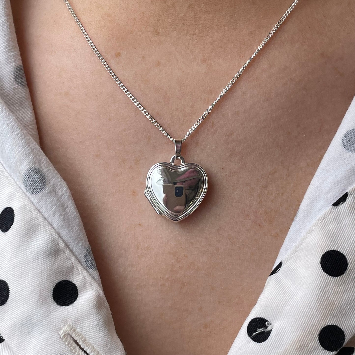 Silver stepped border heart locket necklace by Clandela, featuring a detailed heart-shaped pendant with elegant stepped border design.