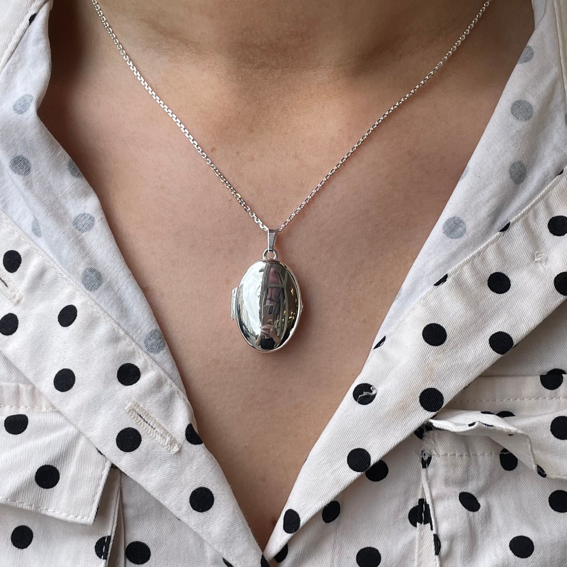Silver Secret Heart Oval Locket Necklace by Clandela featuring a heart-shaped oval pendant on a sleek chain.