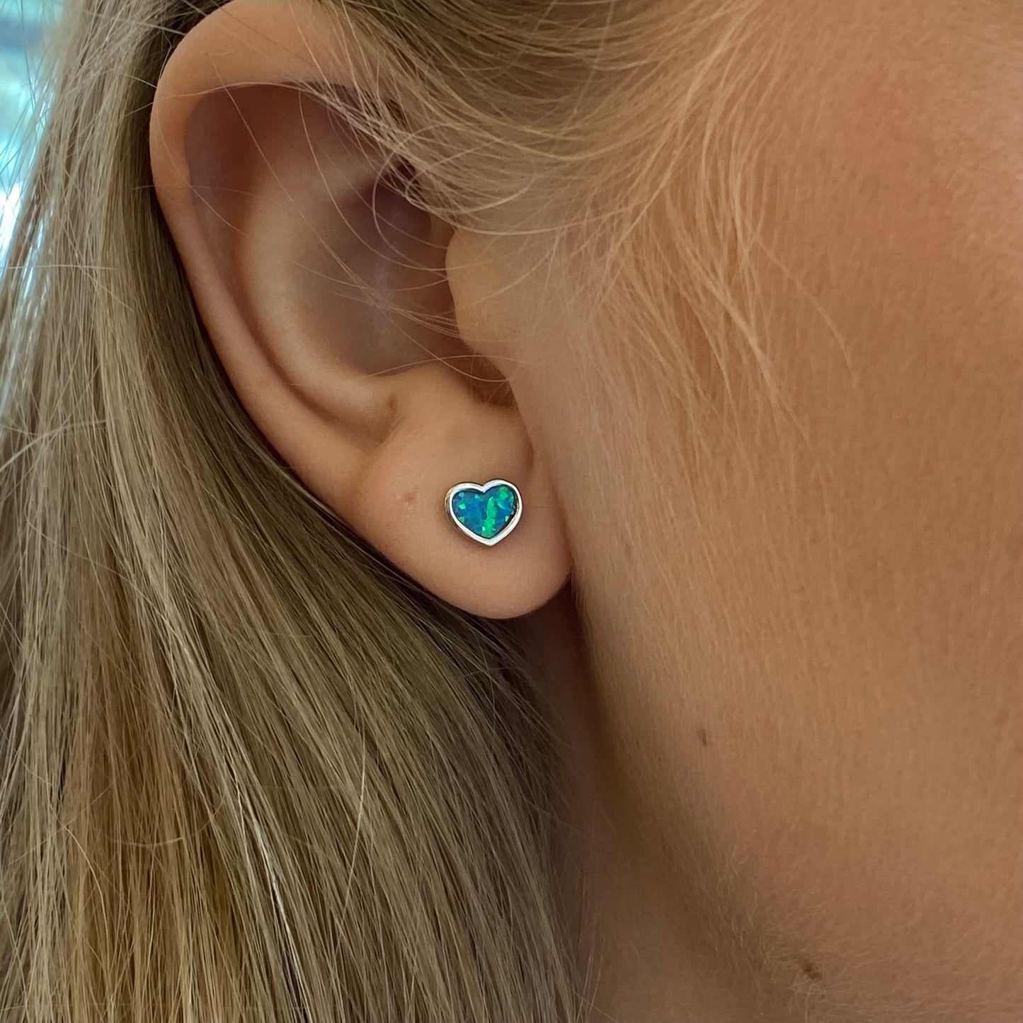 Silver blue opalique heart stud earrings by Insignia featuring shimmering gemstone accents and classic stud design.