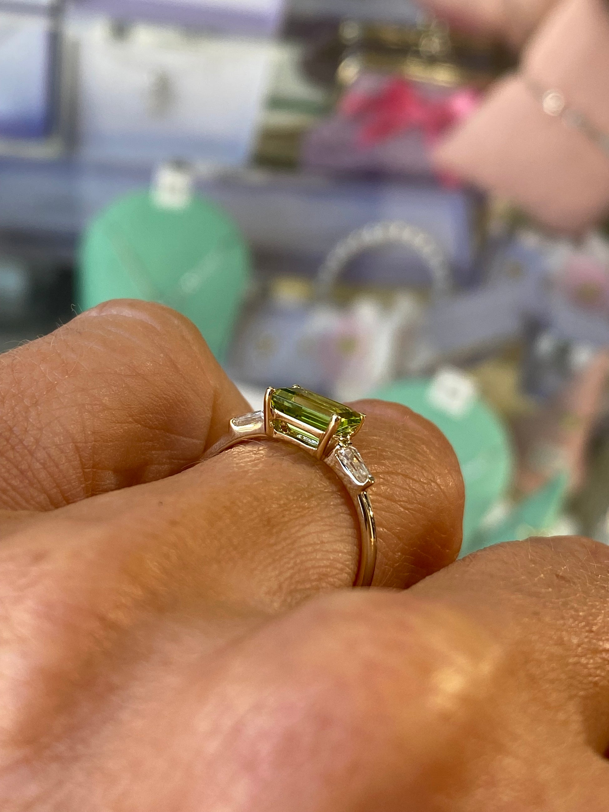 Insignia 9ct gold east-west ring featuring a peridot gemstone and cubic zirconia accents, showcasing elegant jewelry design.