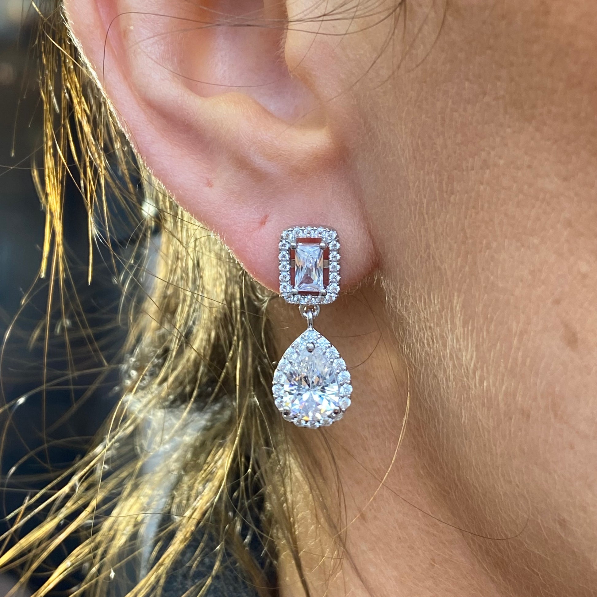 Silver Pear and Radiant Halo CZ drop earrings by Comero featuring pear-shaped and halo-design cubic zirconia stones.