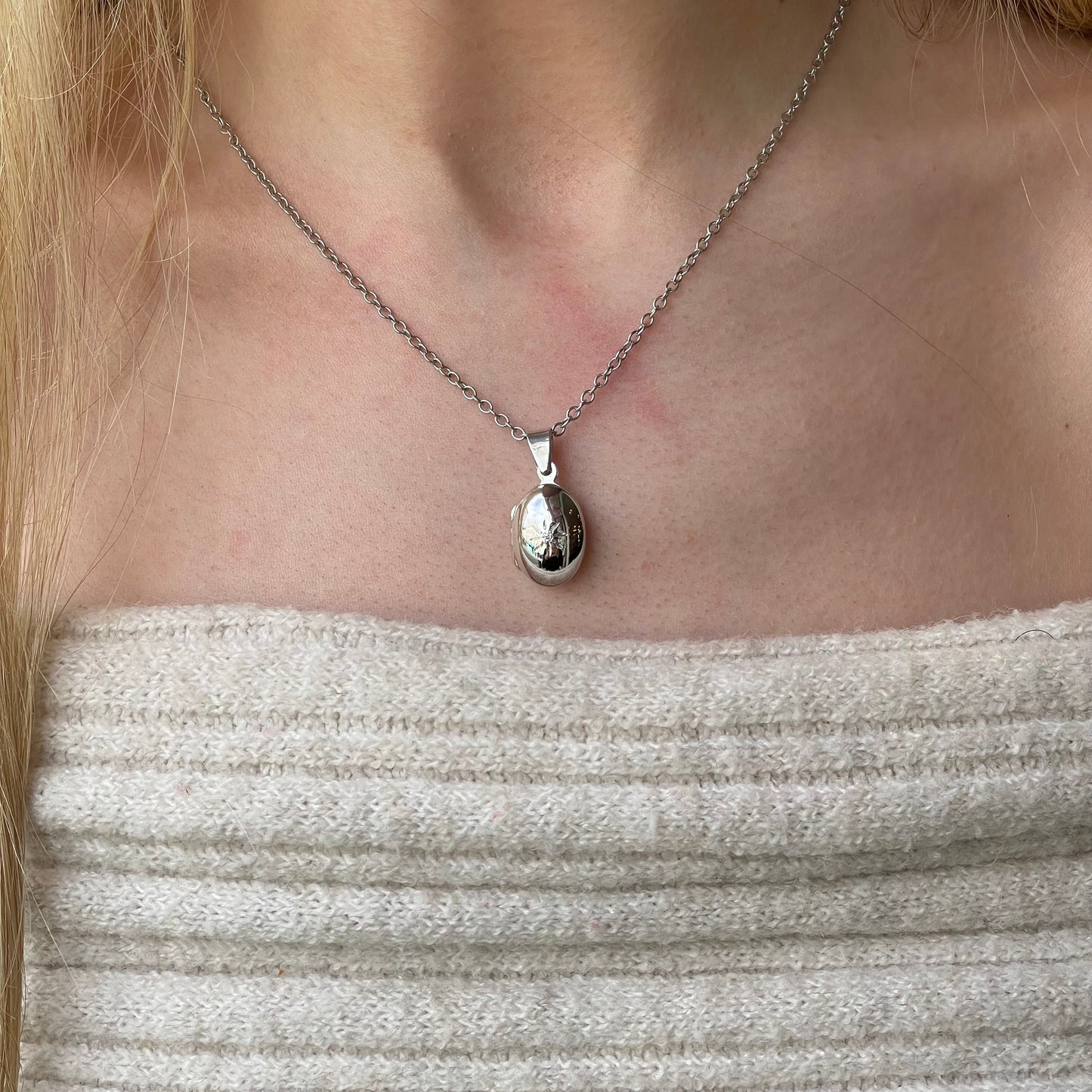 Silver CZ oval locket necklace with chain by Insignia, featuring a polished oval pendant and adjustable chain.