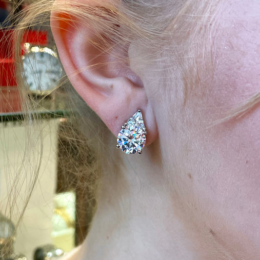 Silver CZ clip-on earrings by Comero featuring sparkling cubic zirconia stones and sleek silver design.