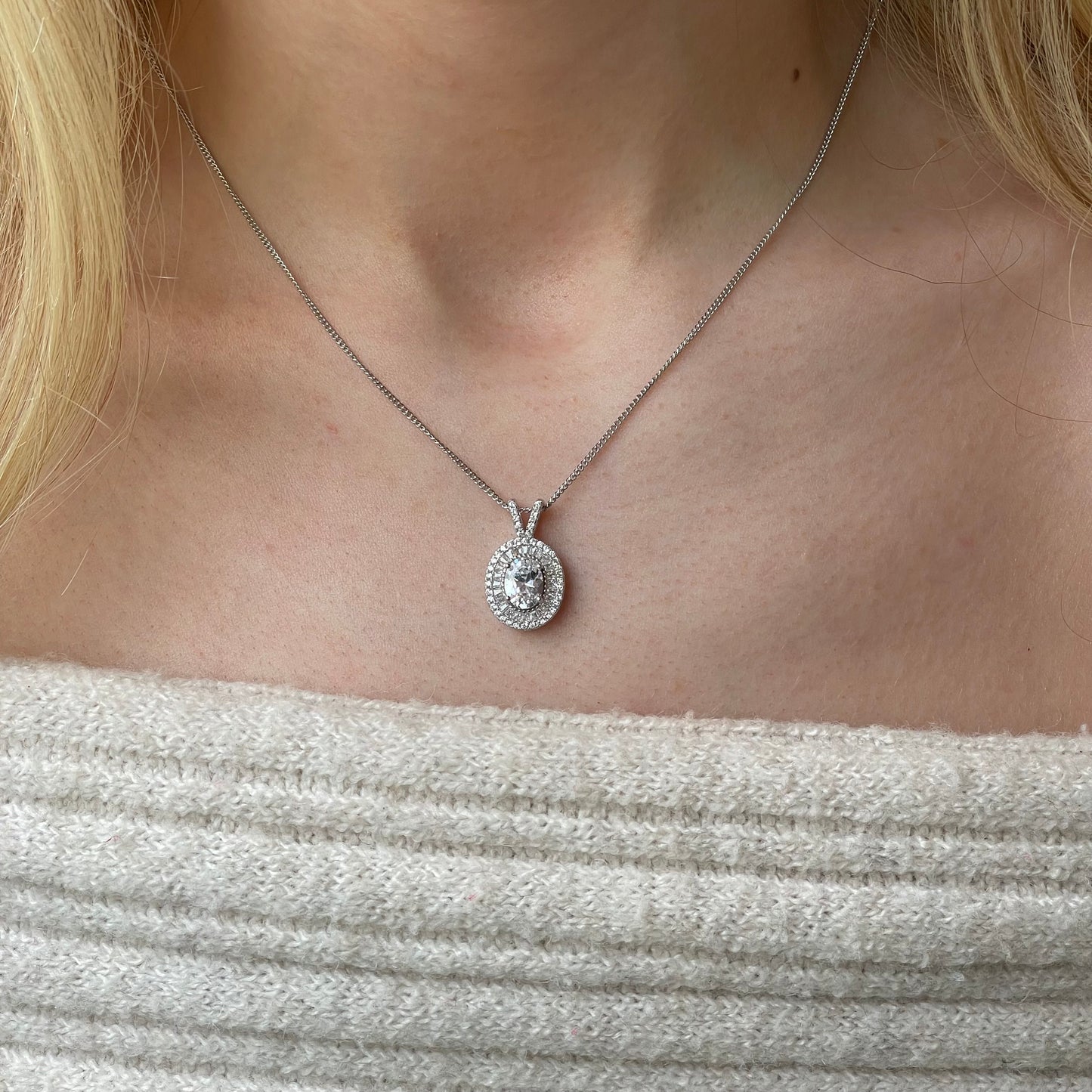 Silver oval CZ halo necklace by Insignia featuring a central oval gemstone surrounded by a sparkling halo design.