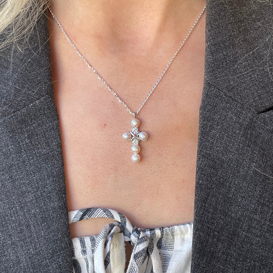 Silver CZ and 5mm freshwater pearl cross necklace with 18-inch chain from Comero, featuring a pendant with sparkling stones and pearls.