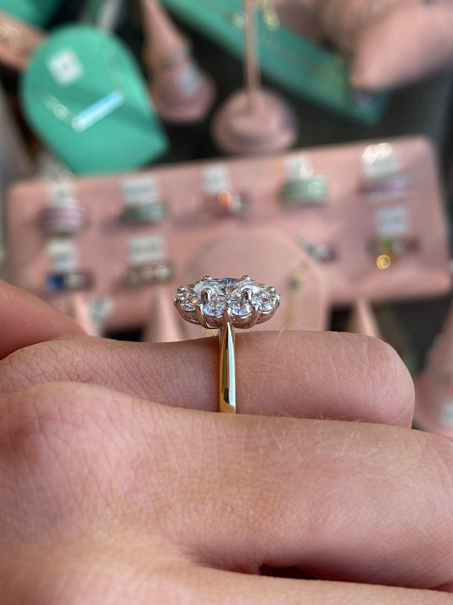 Prima 18ct gold oval cluster engagement ring with a detailed design and sparkling gemstones on a white background.