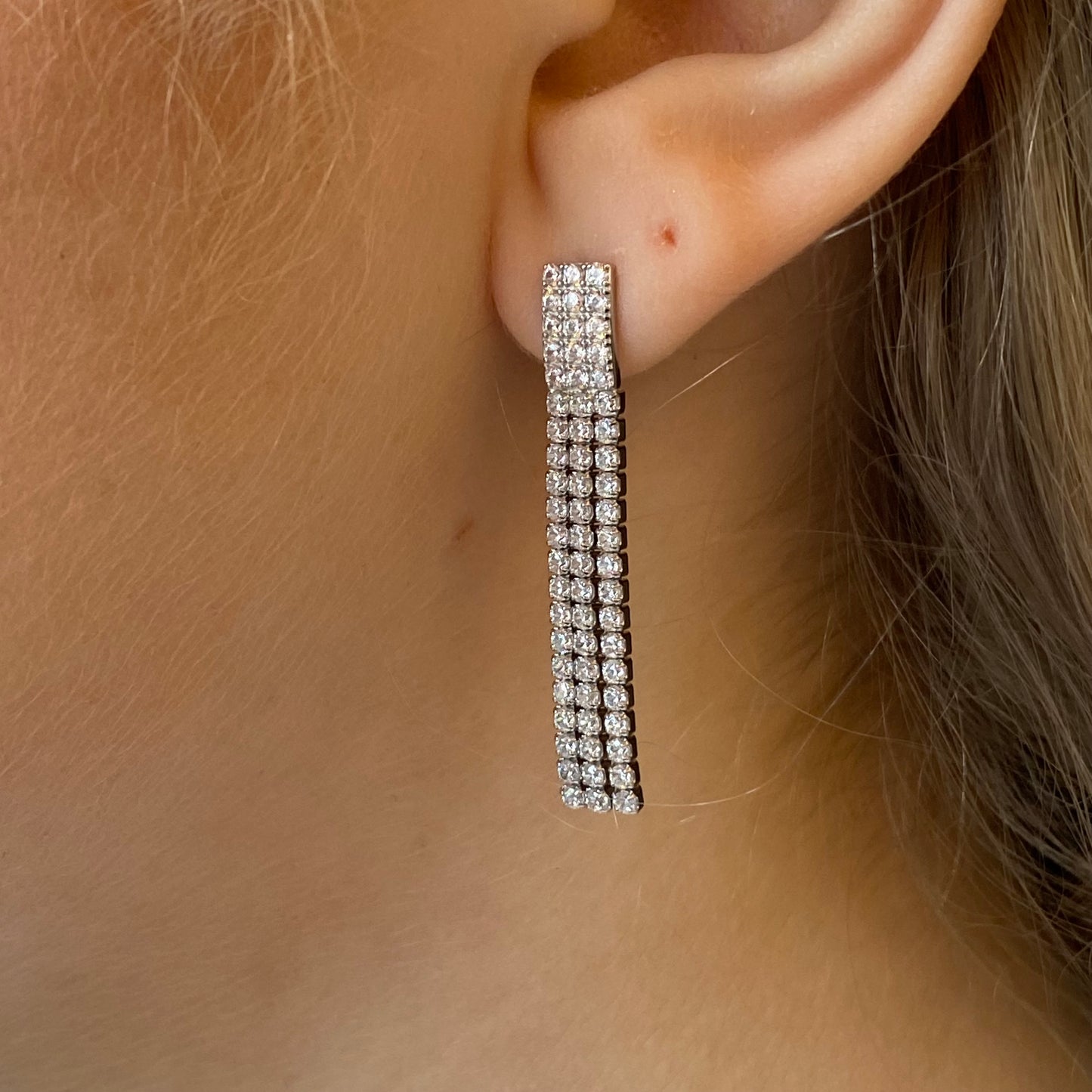 Silver long tennis drop earrings by Comero featuring sleek, shiny silver design with elegant drop style for formal or casual wear.