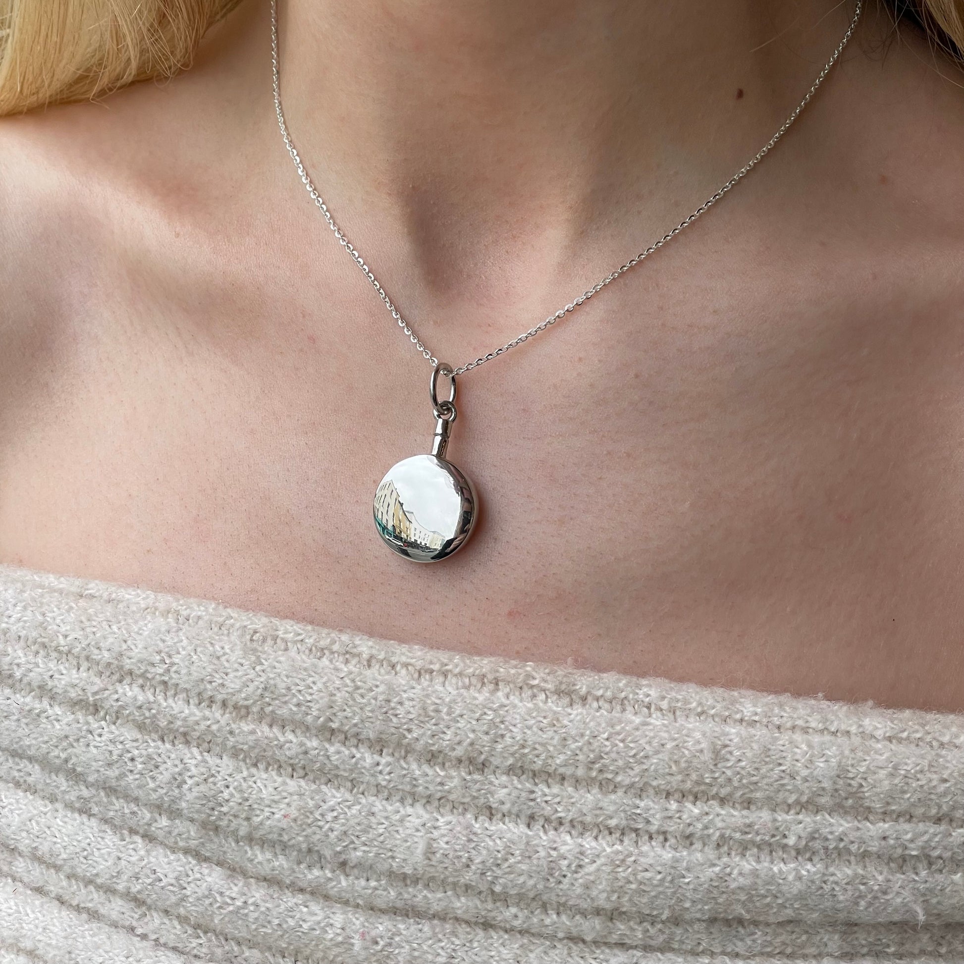 Silver round ash locket necklace by Insignia with a polished silver pendant and chain, showcasing a sleek, elegant design.