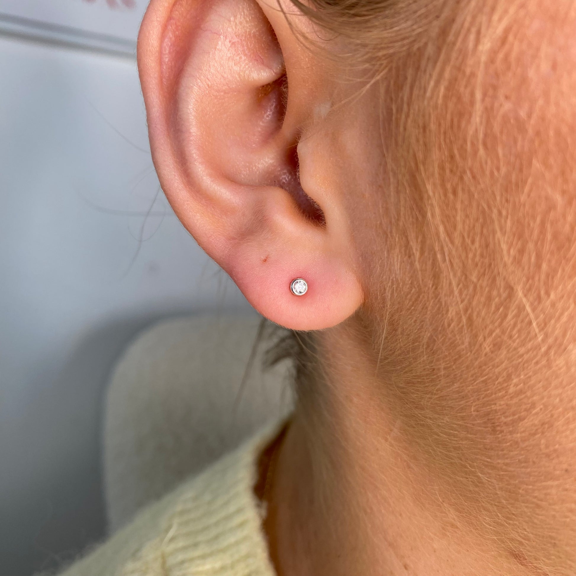 Kid's silver stud earrings with 1mm cubic zirconia bezel set in classic design by Comero.