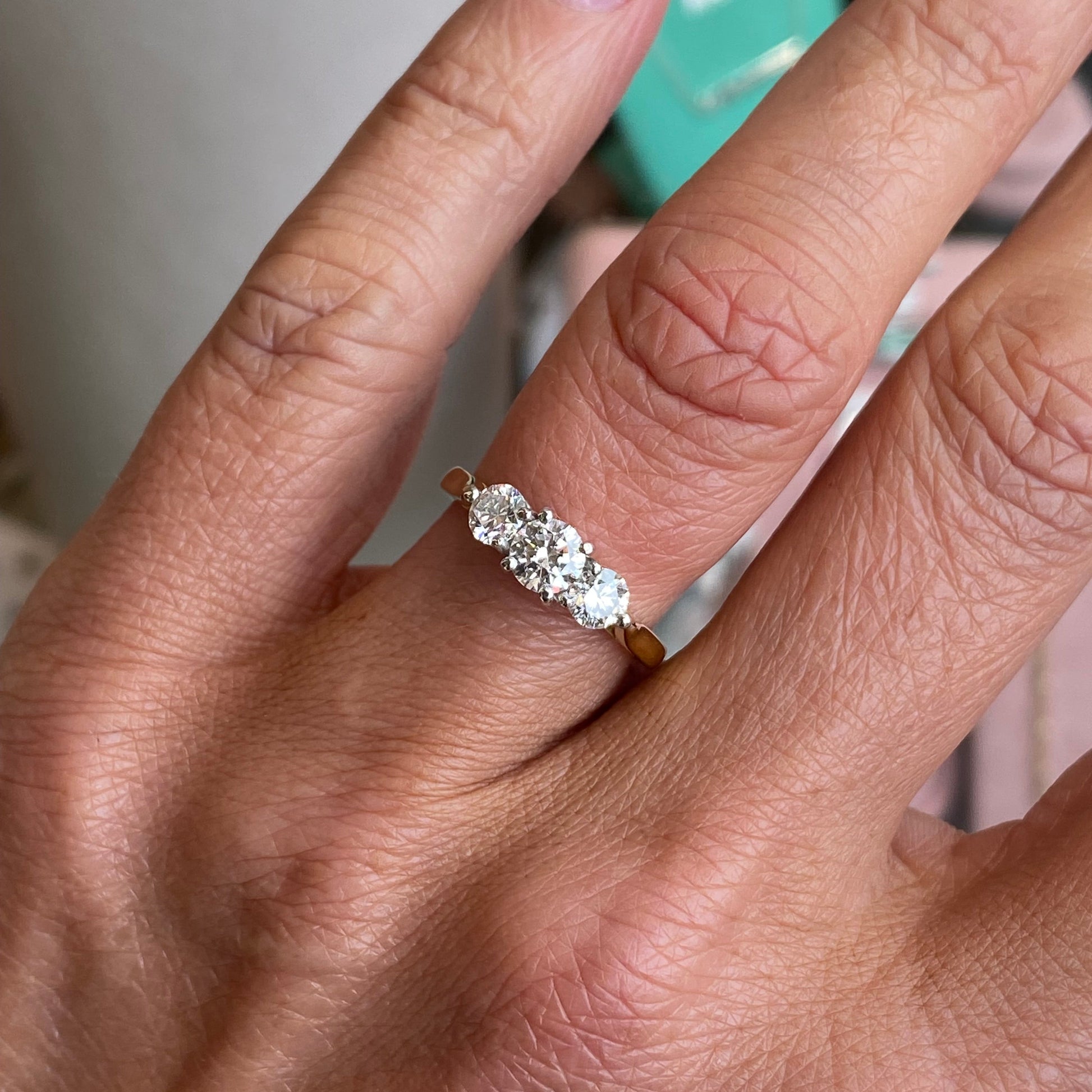 18ct gold trilogy diamond ring by FEU with a 1.00ct central diamond and two side diamonds, showcasing elegant design and sparkle.