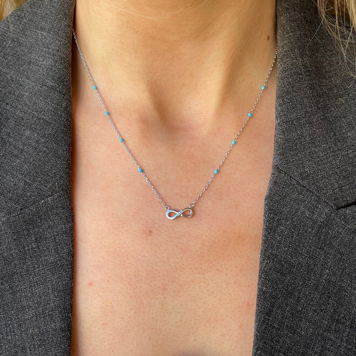 Silver synthetic turquoise infinity necklace by Comero, featuring a delicate design and adjustable length of 42+3cm.