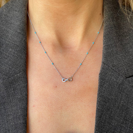 Silver synthetic turquoise infinity necklace by Comero, featuring a delicate design and adjustable length of 42+3cm.