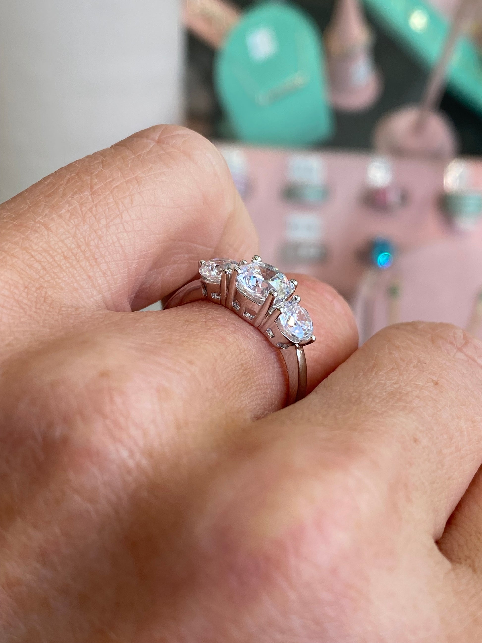 Silver CZ trilogy ring by Insignia featuring three sparkling cubic zirconia stones set in a sleek silver band.