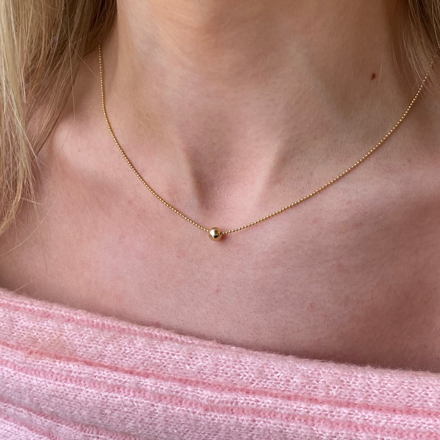 Sunshine Polka Dot Slider Necklace by Comero featuring a vibrant yellow pendant with white polka dots on a gold chain.