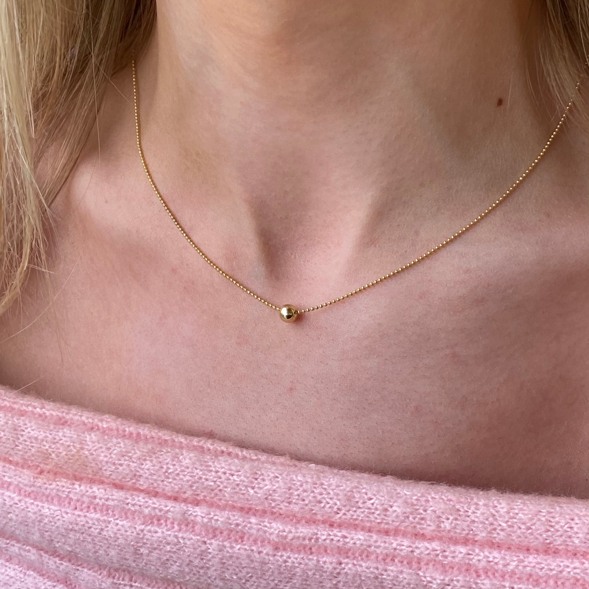 Sunshine Polka Dot Slider Necklace by Comero featuring a vibrant yellow pendant with white polka dots on a gold chain.