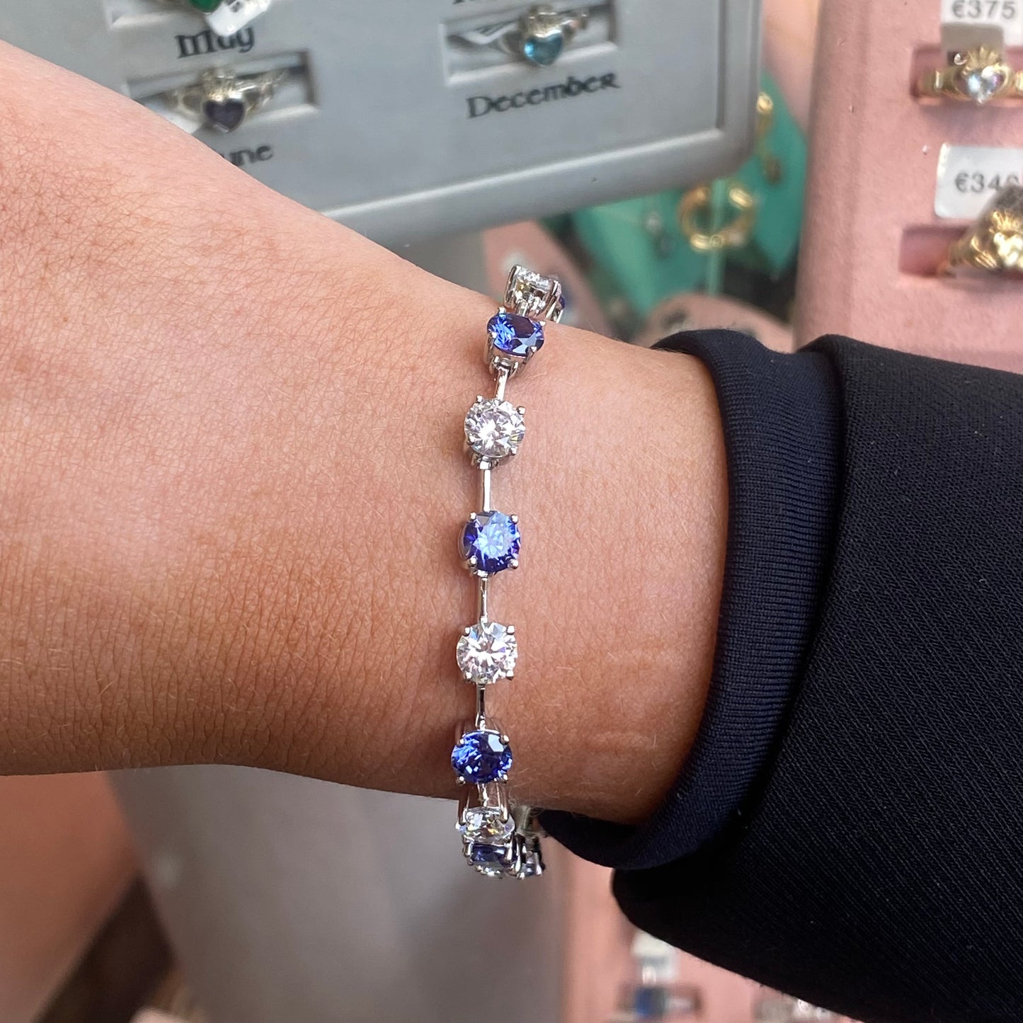Silver CZ tennis bracelet with tanzanite blue accents, featuring sparkling cubic zirconia stones and a delicate chain design.