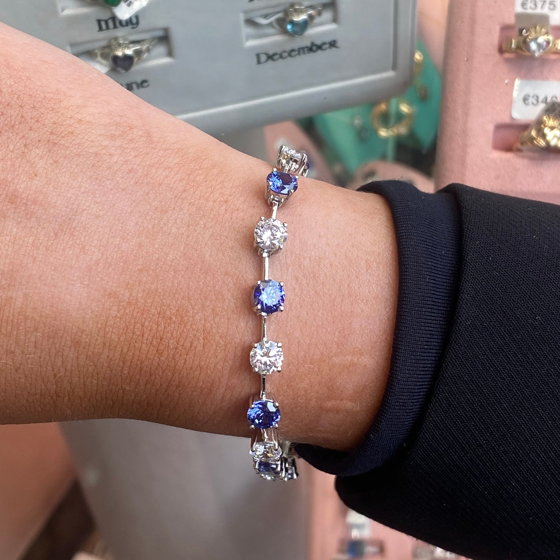 Silver CZ tennis bracelet with tanzanite blue accents, featuring sparkling cubic zirconia stones and a delicate chain design.