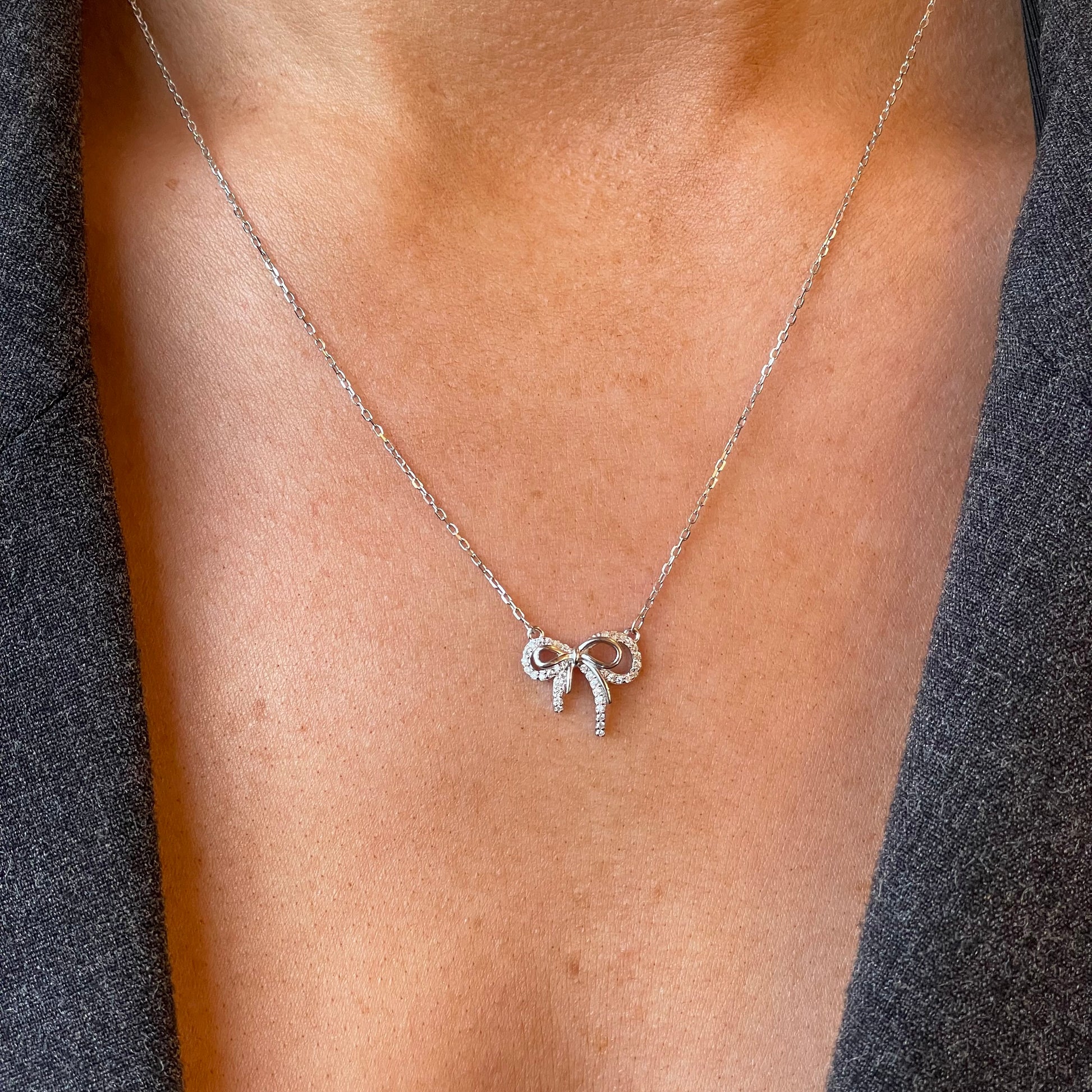 Silver CZ bow necklace with 42+3cm chain, jewelry by Comero featuring a delicate bow pendant and sparkling cubic zirconia stones.