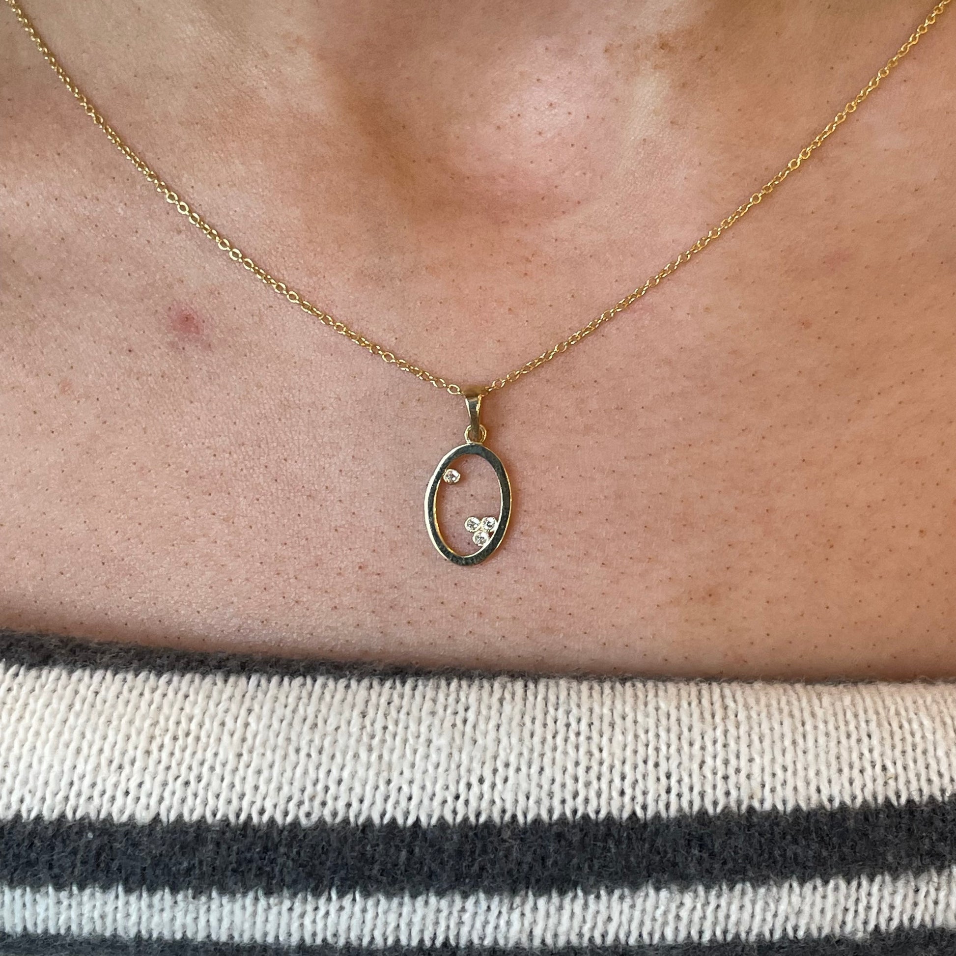 9ct gold open oval necklace with sparkling cubic zirconia from THC, showcasing a delicate chain and elegant pendant design.