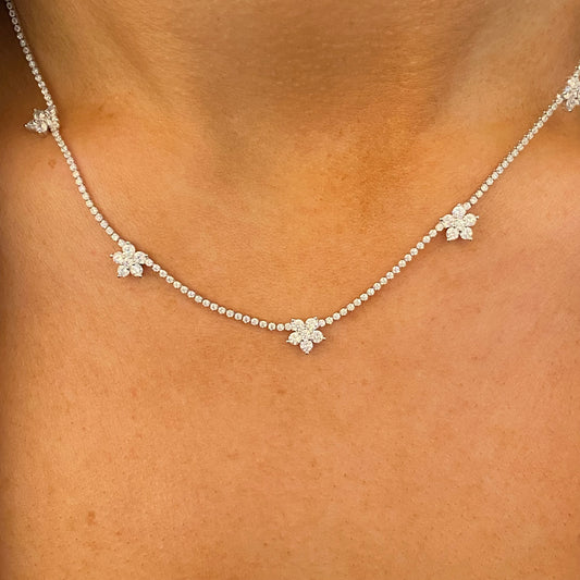 Silver floral CZ fringe necklace by Comero with intricate floral design and long chain, showcasing sparkling cubic zirconia details.
