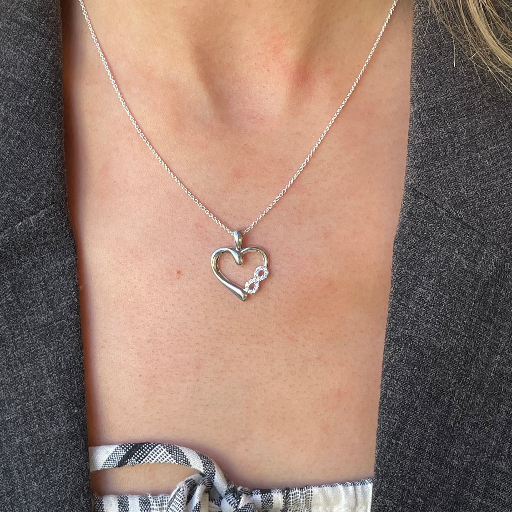 Silver CZ love forever pendant necklace by Comero, displayed on a delicate 18-inch chain against a neutral background.