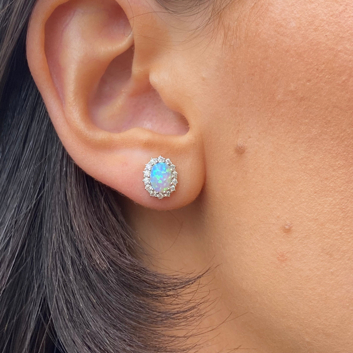 Silver CZ halo opalique stud earrings from Insignia featuring a sparkling central stone surrounded by a halo of smaller stones.