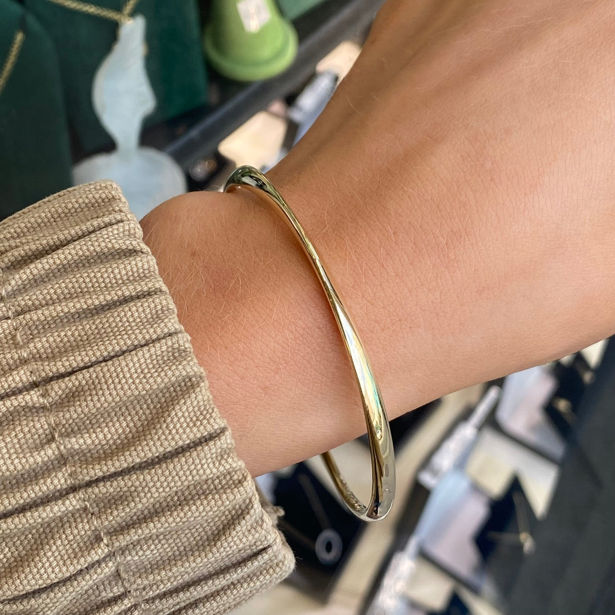 Stubbs 9ct gold plain polished ribbon twist bangle with a 4mm width, showcasing a sleek, elegant jewelry design.