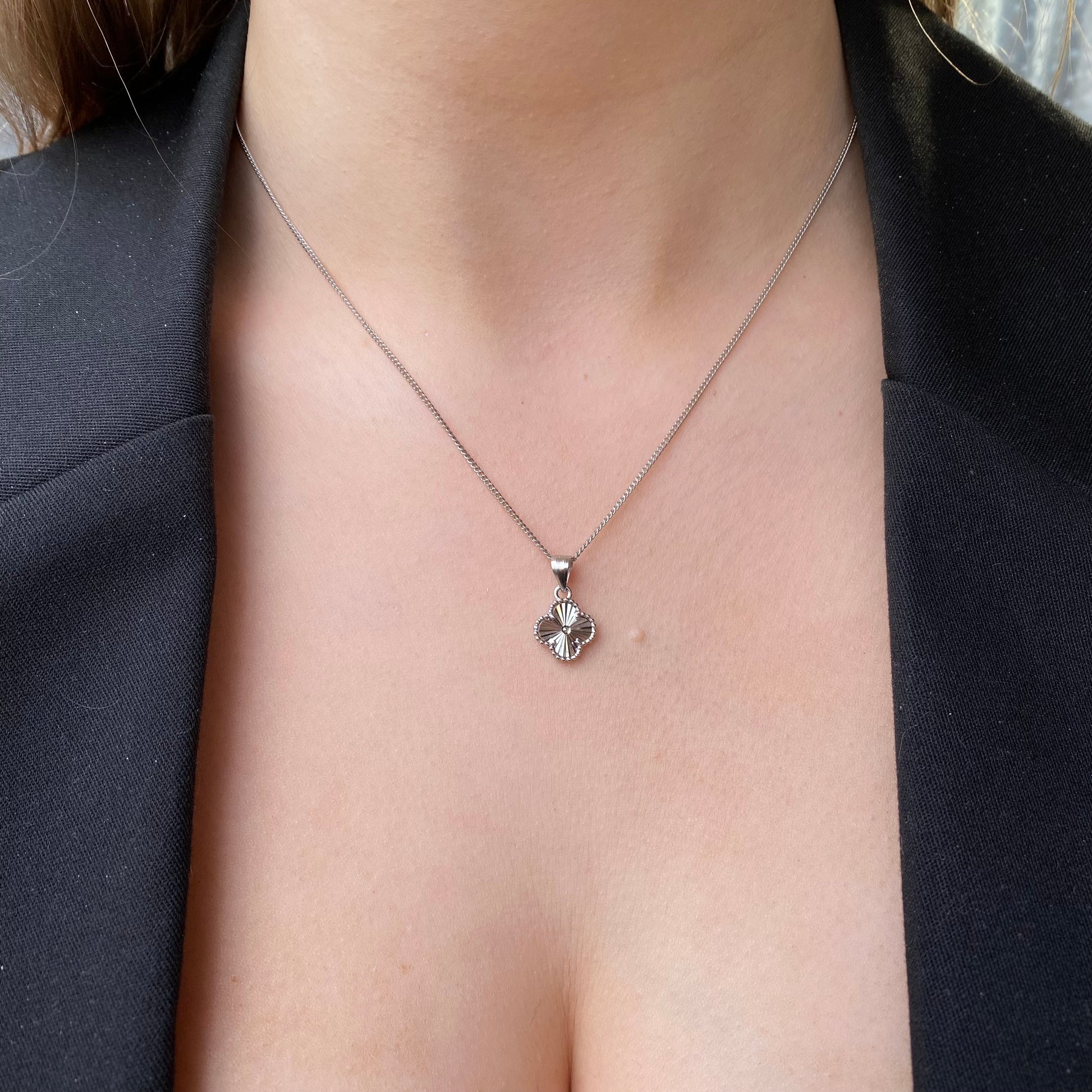 Silver quatrefoil earring and necklace set by Insignia featuring elegant jewelry with geometric design and polished finish.