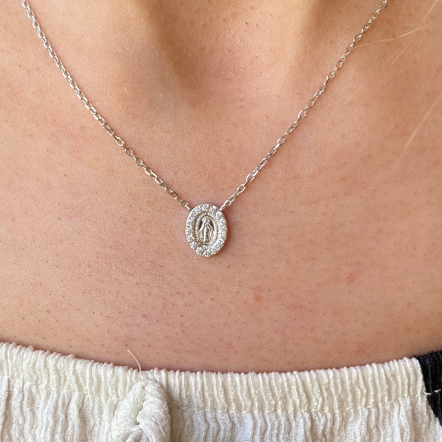 Silver CZ Miraculous Necklace by Comero featuring a detailed religious pendant on a delicate chain.