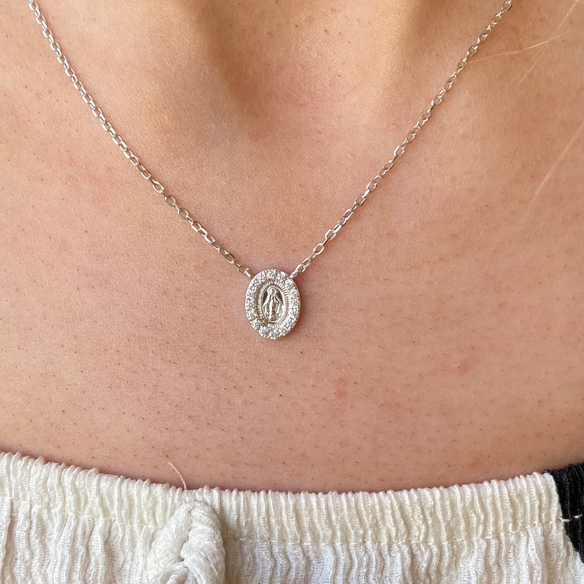 Silver CZ Miraculous Necklace by Comero featuring a detailed religious pendant on a delicate chain.
