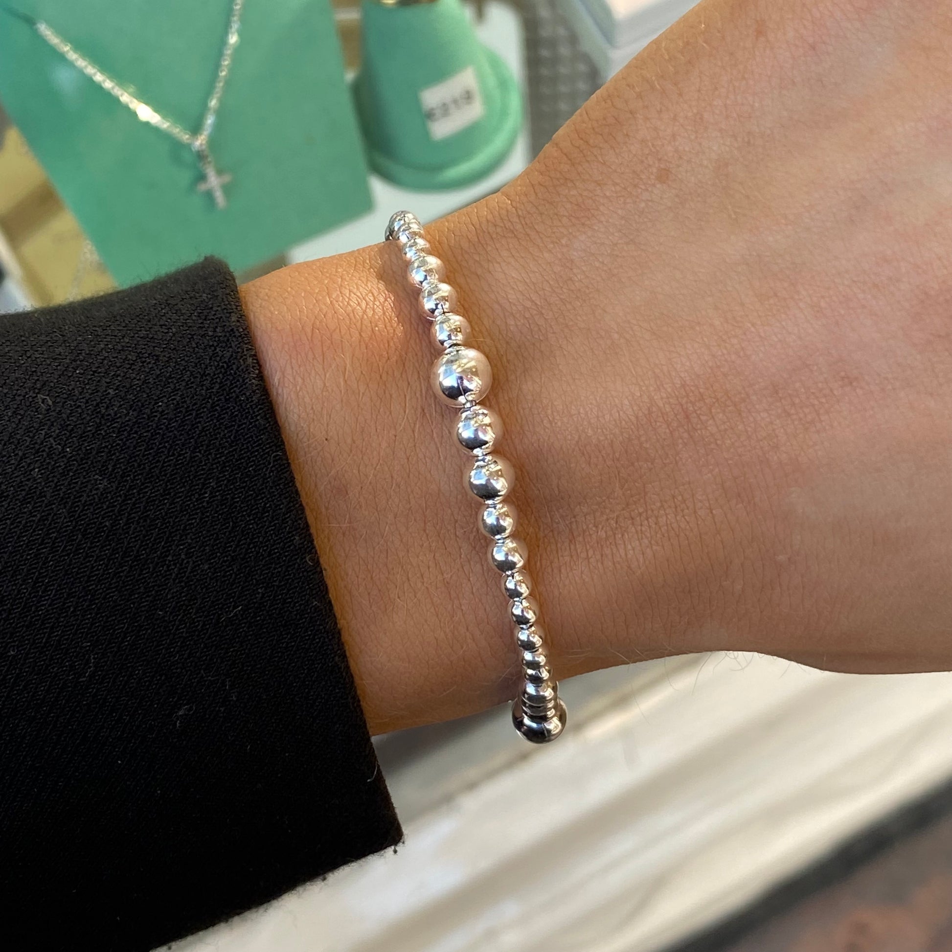 Silver beaded bracelet by Insignia with graduated bead sizes, featuring a sleek and stylish design on a neutral background.