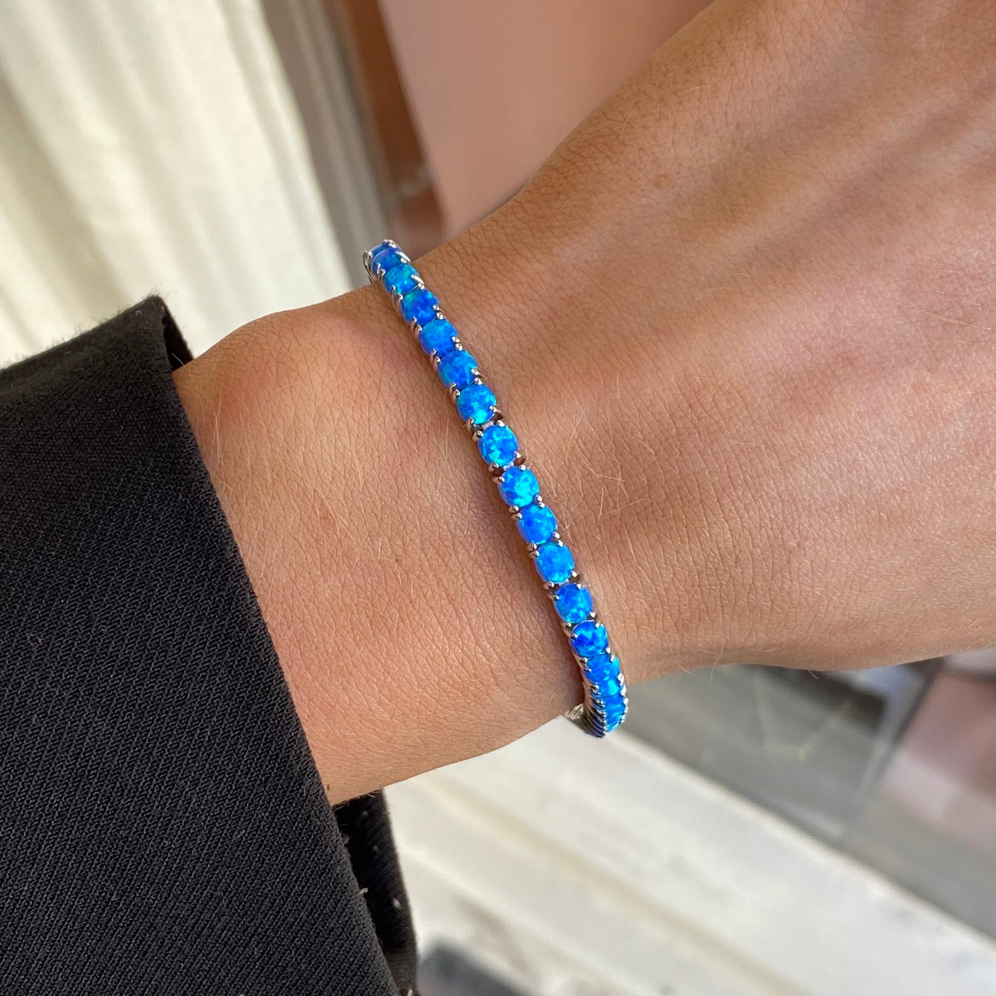 Silver blue opalique tennis bracelet by Insignia featuring sparkling oval and round gemstones on a delicate silver chain.