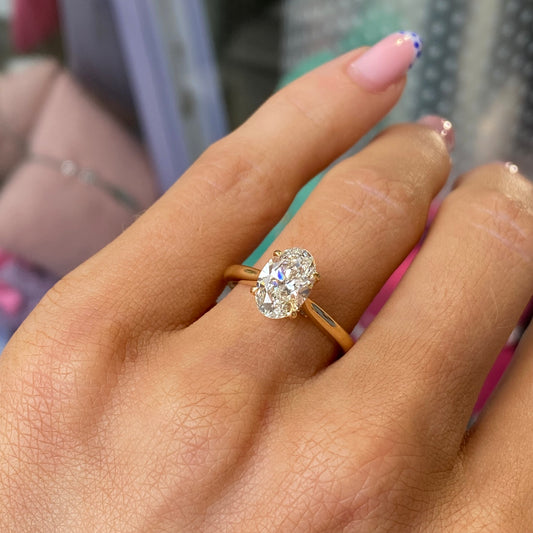 18ct gold oval solitaire engagement ring with 1.53ct certified lab diamond, featuring a sleek band and a prominent central gemstone.