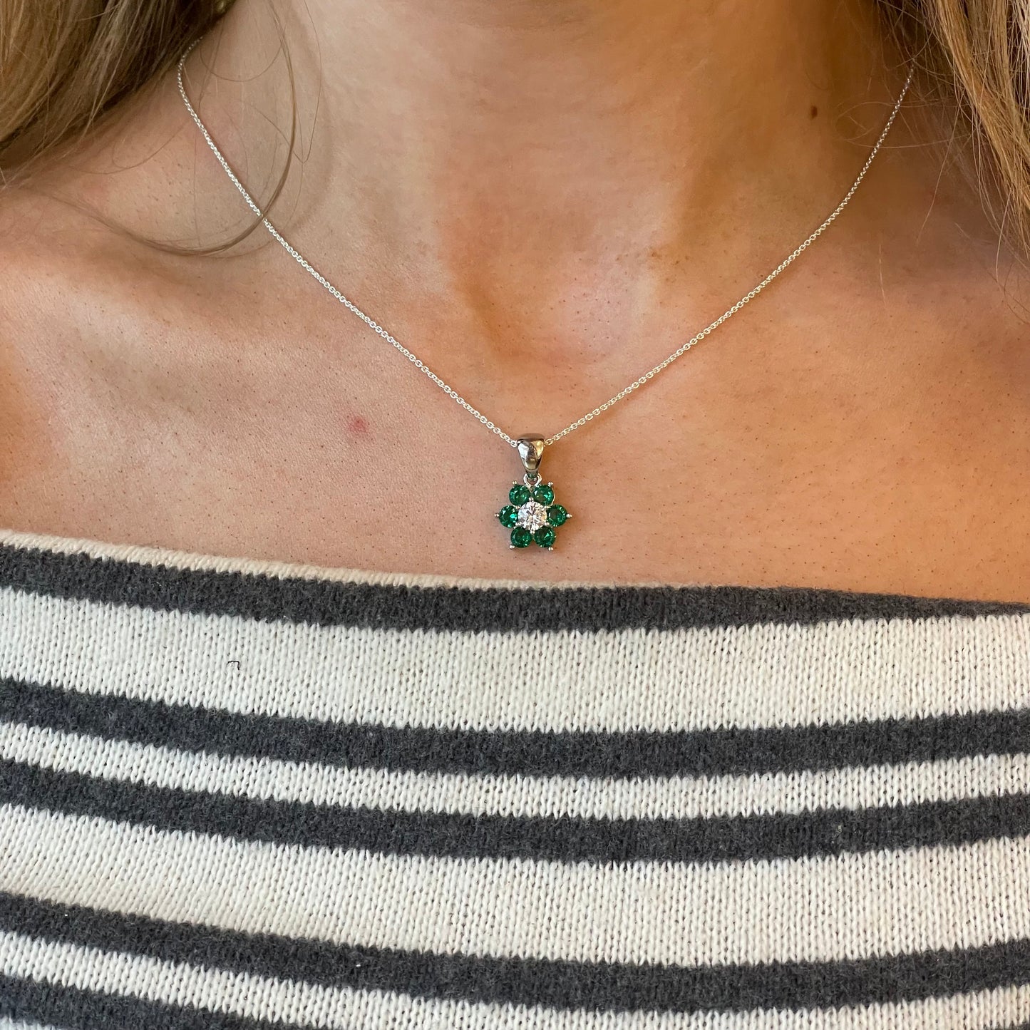 Silver flower cluster CZ pendant necklace with emerald green accents on an 18-inch chain by Comero.