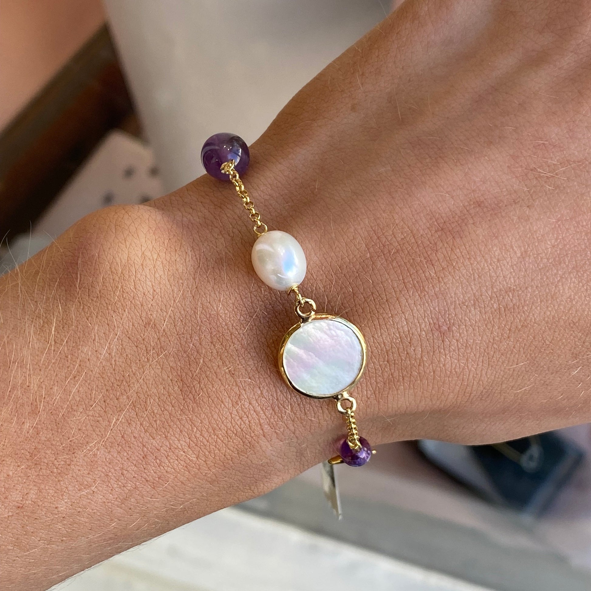 Bruno amethyst, pearl, and mother of pearl bracelet featuring polished beads on a delicate string.
