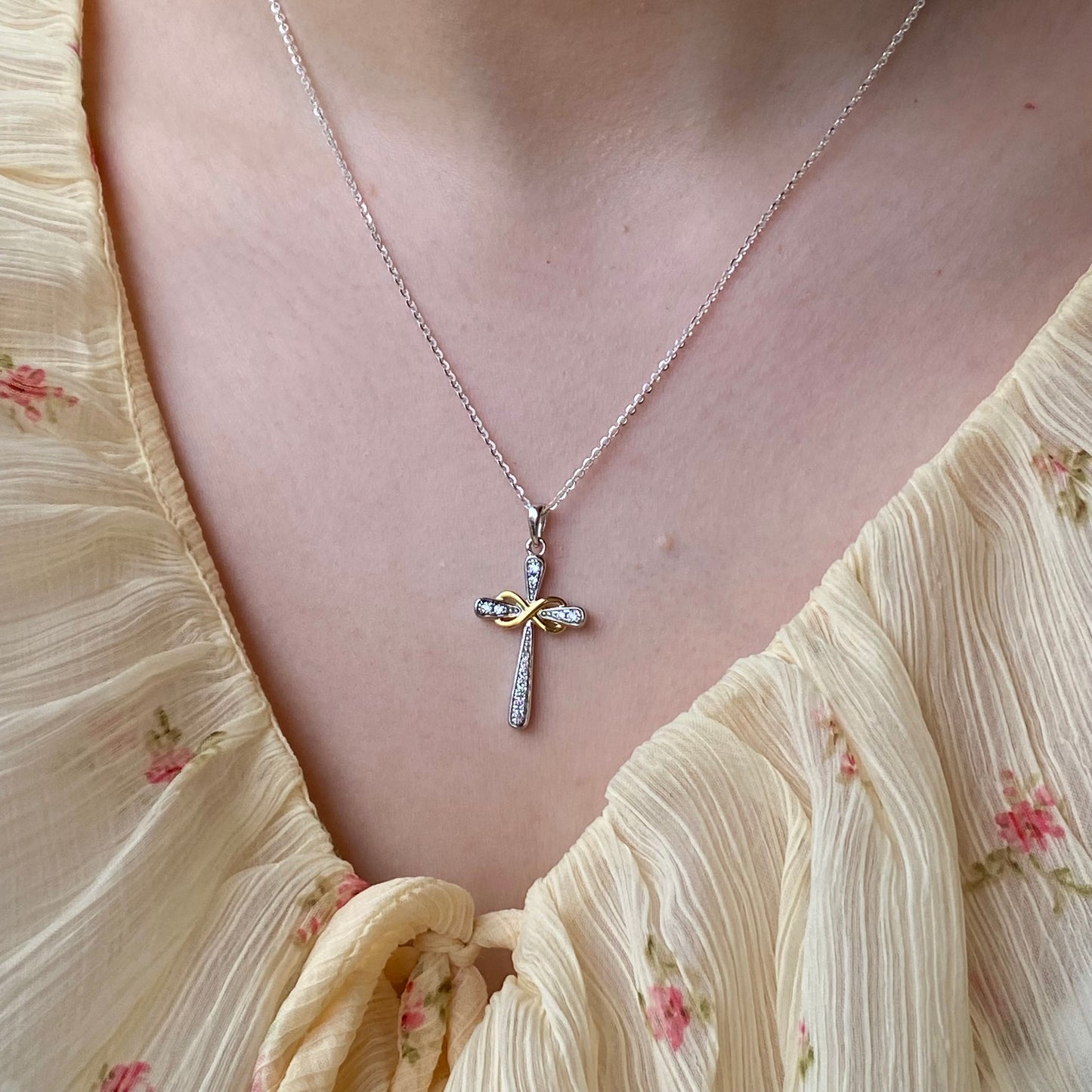 Silver CZ infinity cross necklace with two-tone design by THC, featuring a detailed pendant on a chain.
