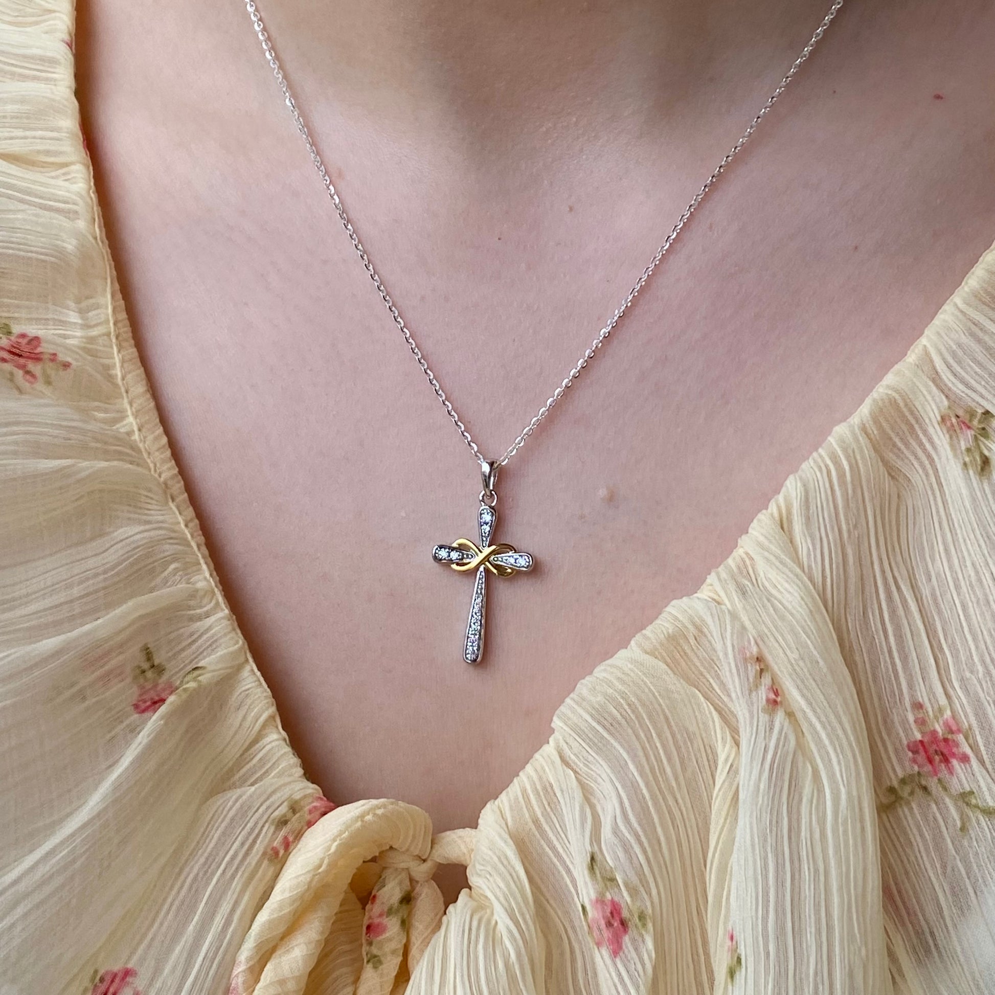 Silver CZ infinity cross necklace with two-tone design by THC, featuring a detailed pendant on a chain.