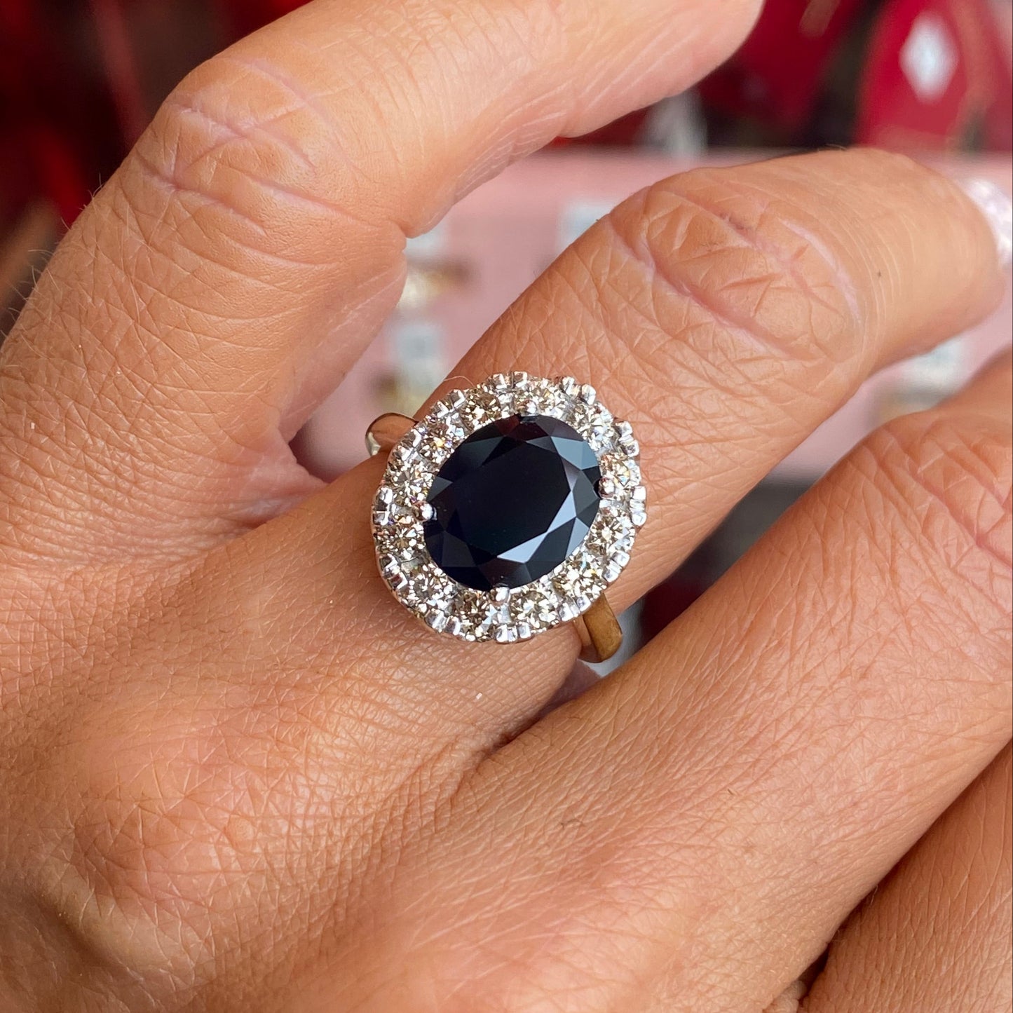 9ct gold sapphire and diamond ring by UJT featuring a central sapphire gemstone and surrounding diamonds.