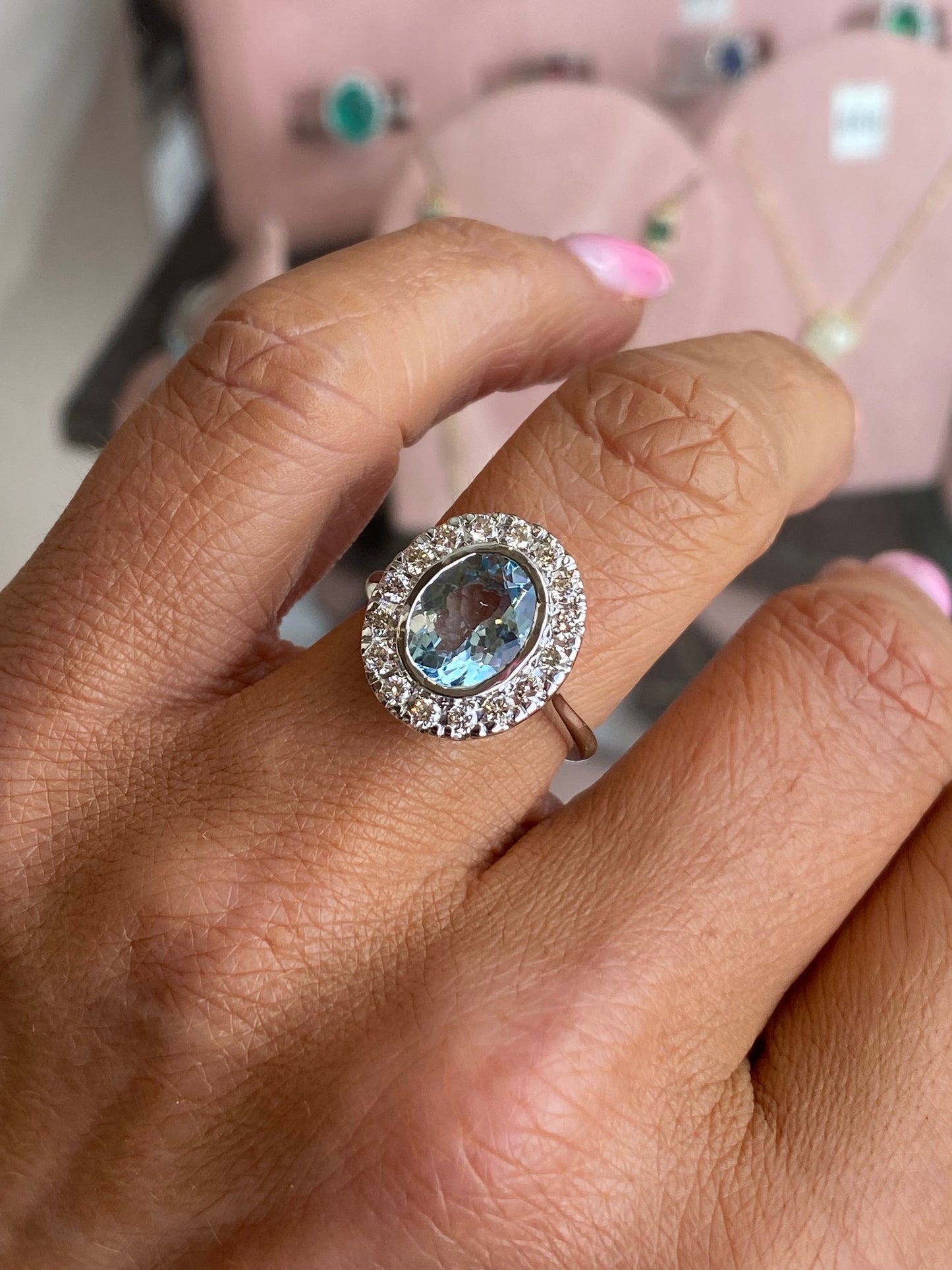 14ct white gold aquamarine and diamond ring with a central oval aquamarine gemstone and sparkling accent diamonds.