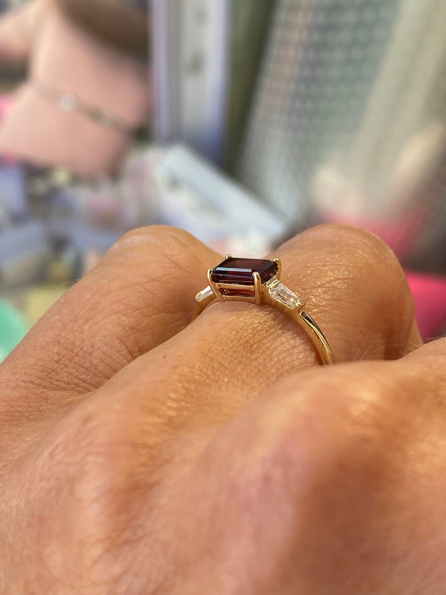 Insignia 9ct gold east west ring featuring a garnet gemstone and cubic zirconia accents, showcasing elegant jewelry design.