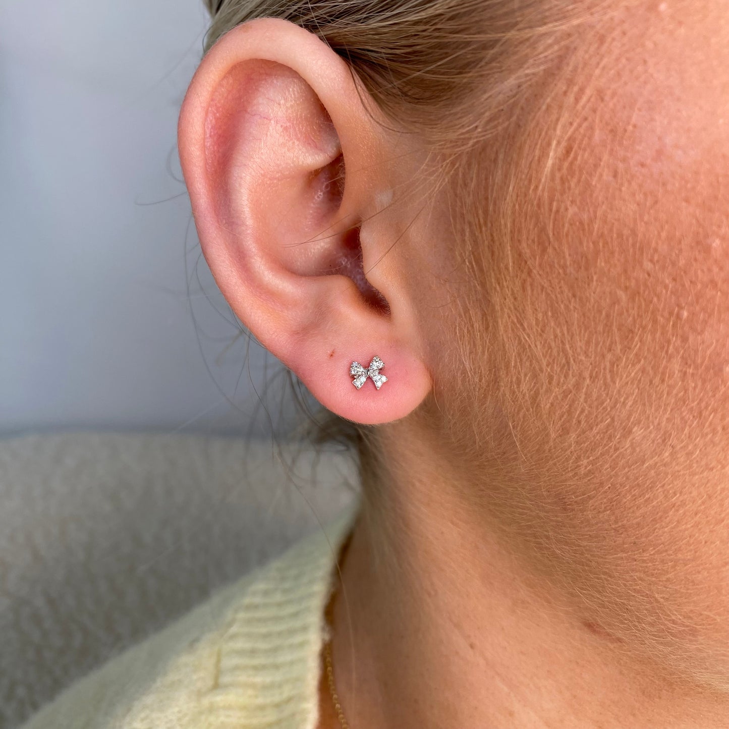 Silver CZ bow stud earrings for kids by Comero, featuring sparkling cubic zirconia and a cute bow design.