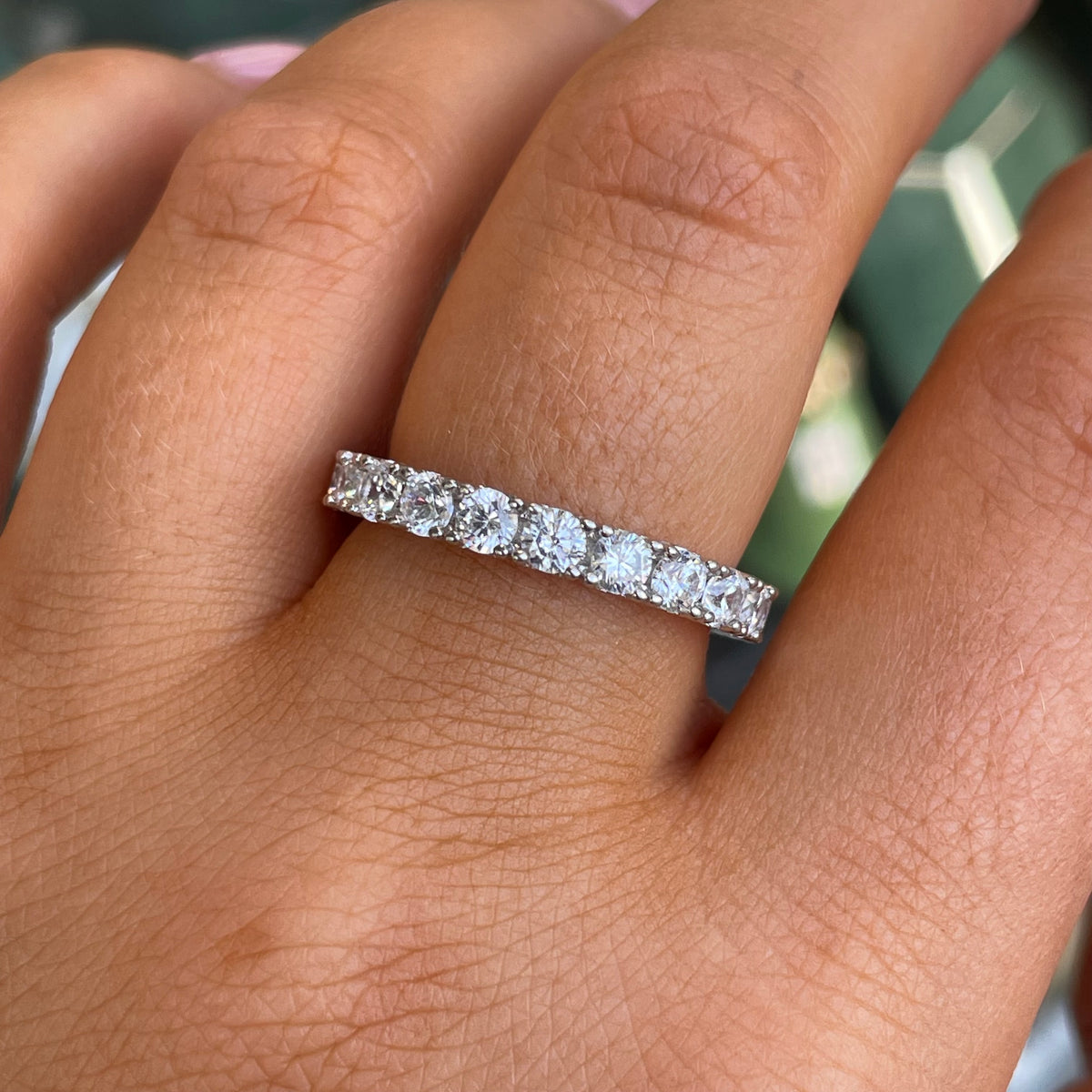 Silver CZ eternity band ring by THC featuring a continuous row of sparkling cubic zirconia stones on a sleek silver band.