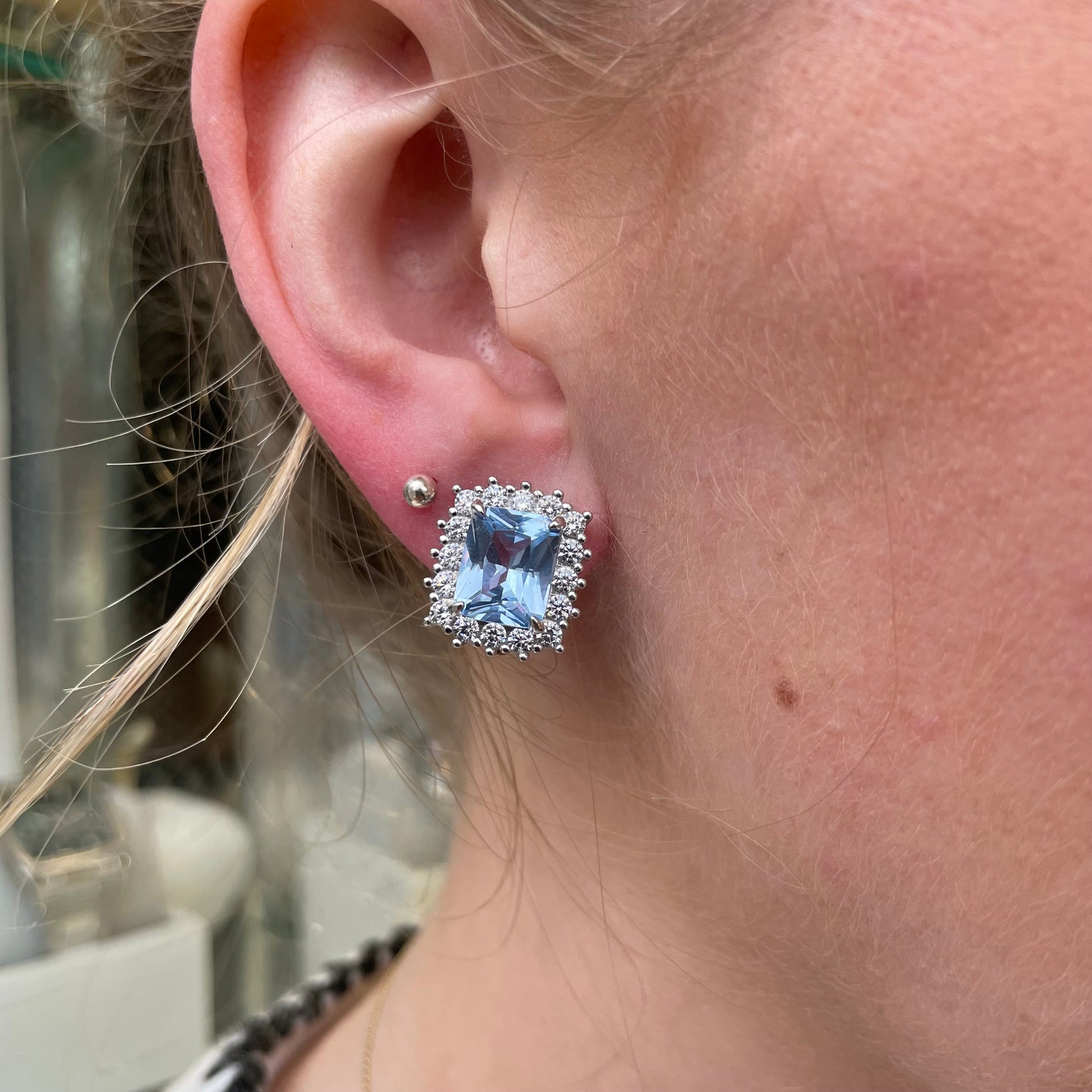 Silver clip-on earrings featuring 10x8mm aqua spinel and CZ stones, showcasing elegant jewelry design.