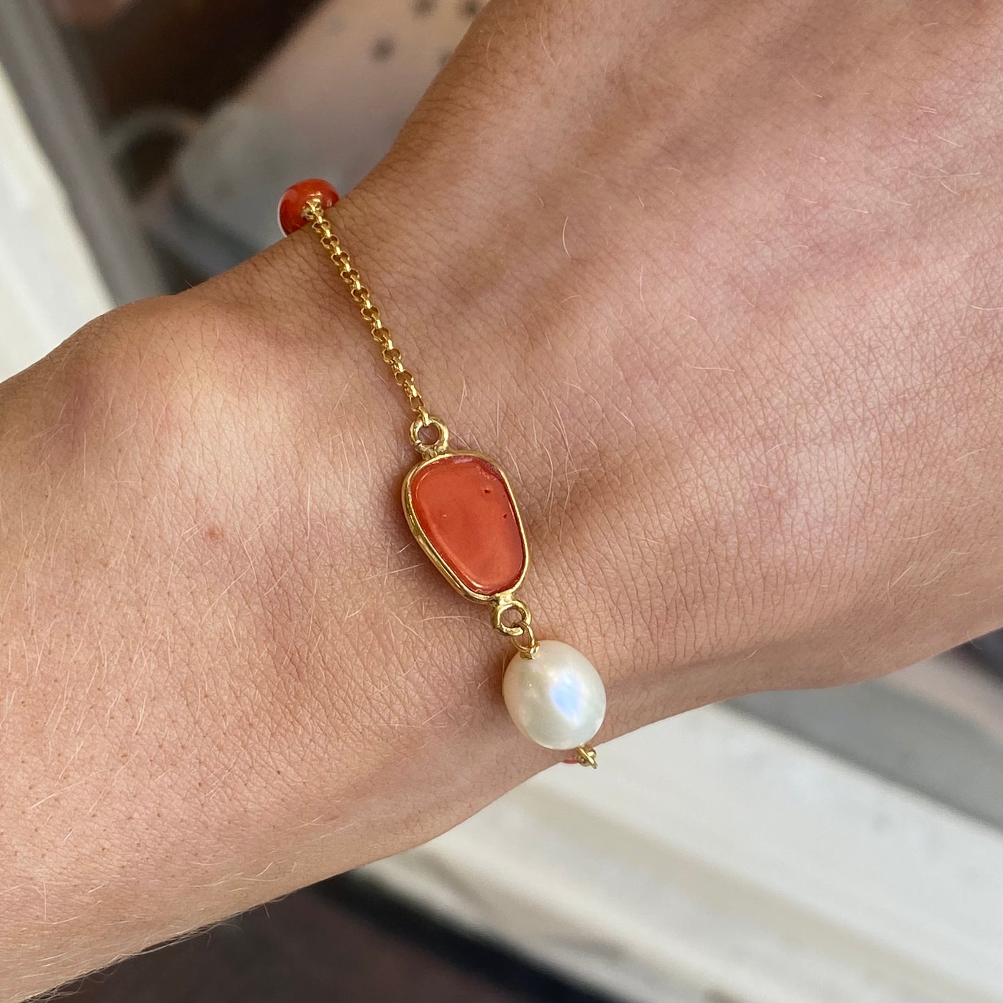 Bruno coral, pearl, and mother of pearl bracelet featuring colorful beads and elegant design on a white background.