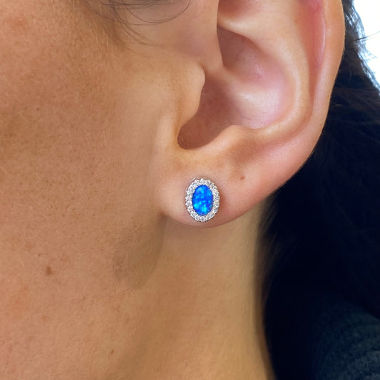 Silver oval blue opalique and CZ halo stud earrings by Insignia featuring elegant gemstone and crystal detailing.
