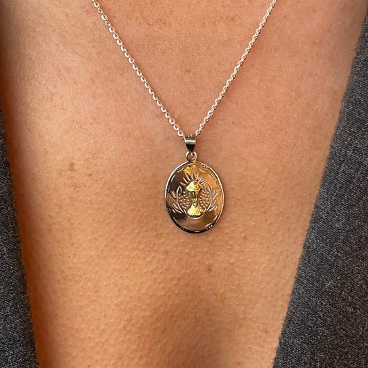 Silver two-tone oval communion medal necklace by Comero, 18-inch chain with detailed religious pendant.